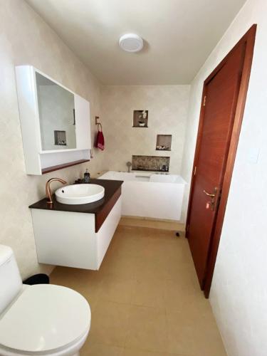 a bathroom with a toilet and a sink and a tub at Appartement luxe grand baie in Grand Baie