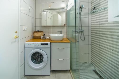 une salle de bain avec une machine à laver et un lavabo dans l'établissement WELCS CASA 283 EMP cerca del mar, à Montjoys
