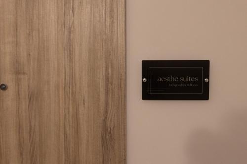 a door with a sign on it next to a wall at Aesthe Suites Noir in Xanthi