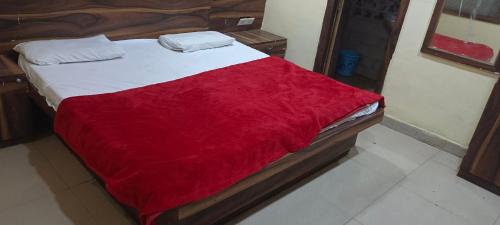 a bed with a red blanket on top of it at Hotel Maharaja in Lucknow