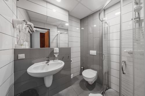 a white bathroom with a sink and a toilet at euroHOTEL Katowice Nikiszowiec in Katowice