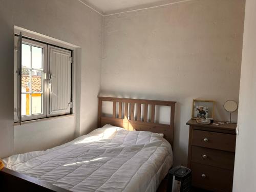 a bedroom with a large bed and a window at Casa Mira in Odemira