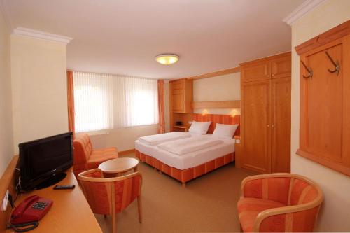 a hotel room with a bed and a television at Landhaus Silberberg in Winterberg
