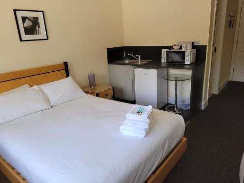 a bedroom with a bed with a towel on it at Nysdill Accommodation Ltd in Norwich