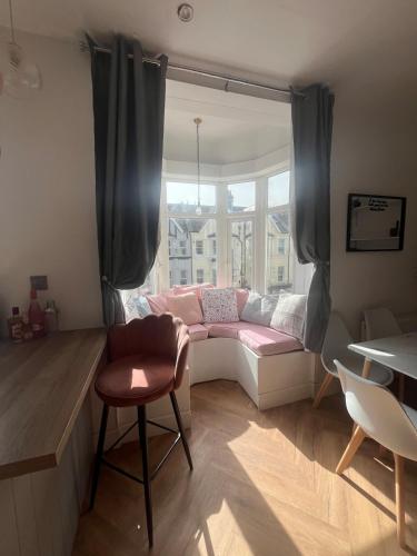 a living room with a pink couch and a window at Seaside 3bed 6person Apartment - Perfect Getaway Retreat in Bexhill