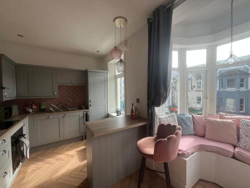 a living room with a pink couch in a kitchen at Seaside 3bed 6person Apartment - Perfect Getaway Retreat in Bexhill