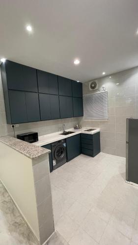 a large kitchen with green cabinets and a dishwasher at Kinda Resort Luxury Villas in Taif