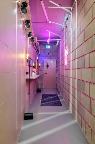 a pink bathroom with a purple ceiling and a corridor at UrbanKey Studios - Vienna Mitte in Vienna