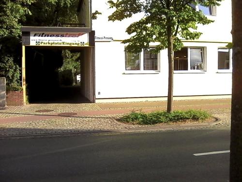 ein Tunnel, der in ein Gebäude mit einem Baum führt in der Unterkunft Fitness Pension in Sulingen