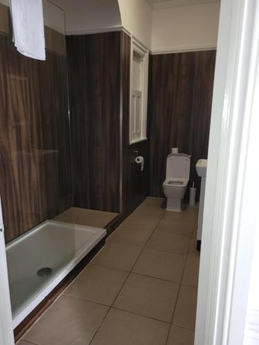 a bathroom with a bath tub and a toilet at Nysdill Accommodation Ltd in Norwich