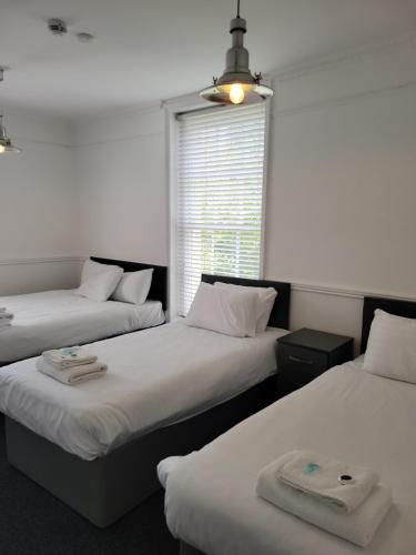 a room with two beds and a window at Nysdill Accommodation Ltd in Norwich