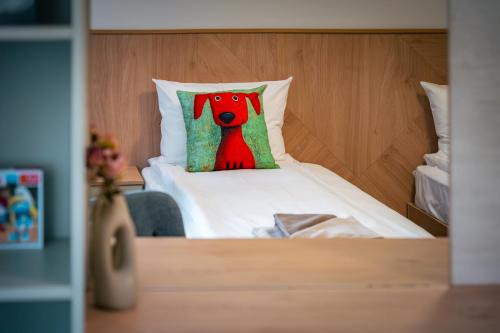 a bed with a pillow with a dog on it at TRINAVIS Boutique Apartments, OWN PRIVATE PARKING, City Center, Entire Apartment in Veliko Tŭrnovo