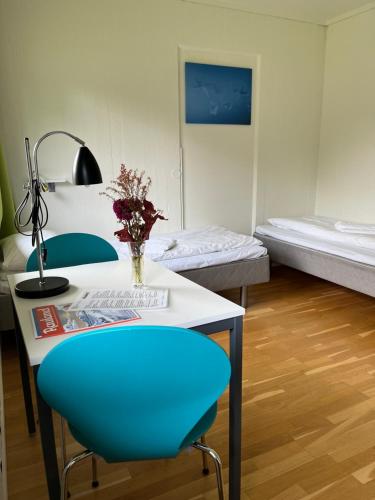 a room with a table and a blue chair and a bed at Raulandsakademiet in Rauland