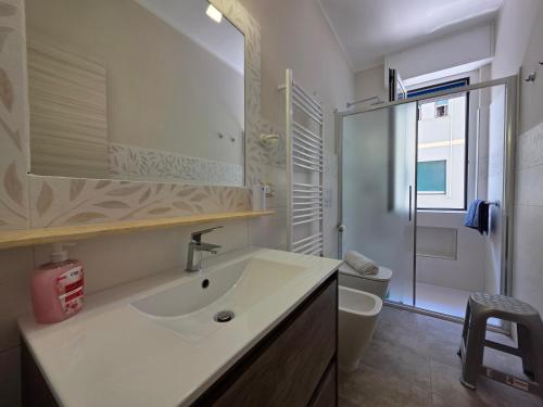 a bathroom with a sink and a toilet and a mirror at 200m from Beach, New Central Apt, AC, WiFi in Loano