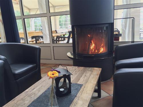 a fireplace in a living room with a table and a fire place at Villa Björkhagen in Jönköping