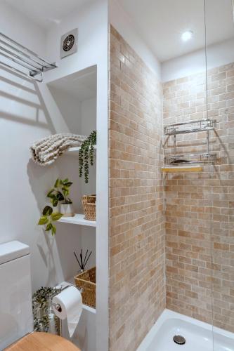 a bathroom with a shower with a brick wall at Finest Retreats - Cawsand Cottage in Cawsand