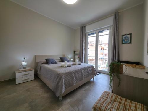 a bedroom with a bed and a large window at 200m from Beach, New Central Apt, AC, WiFi in Loano