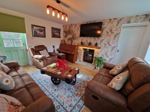 a living room with leather furniture and a fireplace at Pen y Fan Cottage Log Burner Brecon Beacons with Breath taking views in Pont Sticill