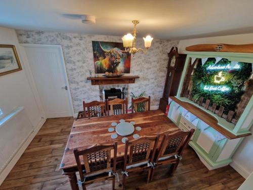 a dining room with a wooden table and chairs at Pen y Fan Cottage Log Burner Brecon Beacons with Breath taking views in Pont Sticill