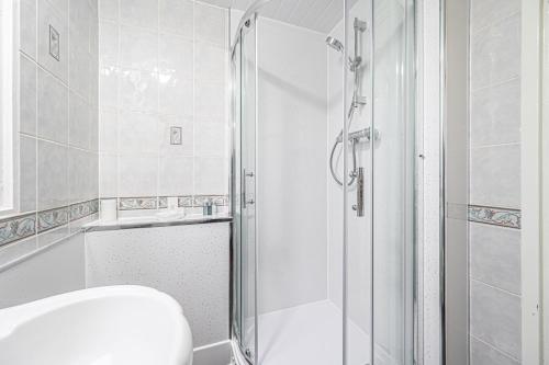 a white bathroom with a shower and a toilet at Pure Home Rosyth Dockyard By Tba in Rosyth