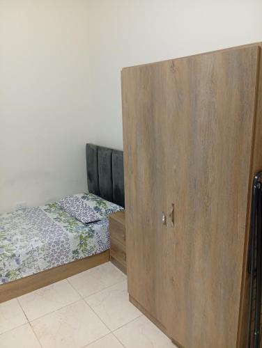 a bedroom with two beds and a wooden door at Masa sharing home private rooms and private bathroom in Amman