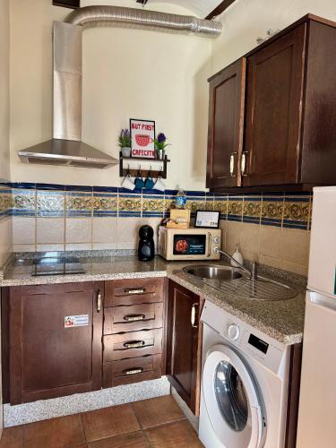 a kitchen with a sink and a washing machine at Apartamento RÚSTICO ÁRABE en el CORAZÓN de Córdoba in Córdoba