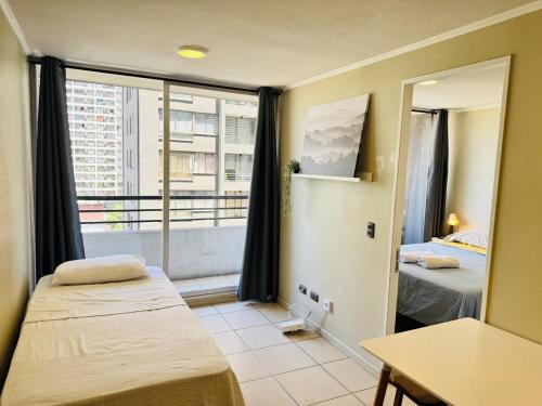 a small room with two beds and a window at Estancia para 3 cerca de Metro in El Cerrillo