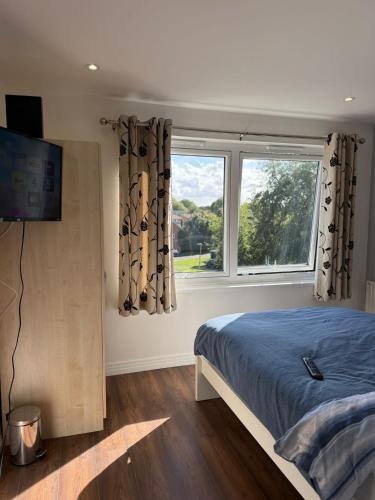 a bedroom with a bed and a window at Modern City Flat, Walk to Hatfield House, Trains and University in Hatfield