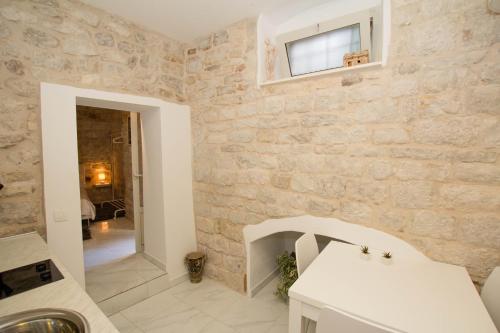 a kitchen with a stone wall and a sink at Apartment Toma in Trogir