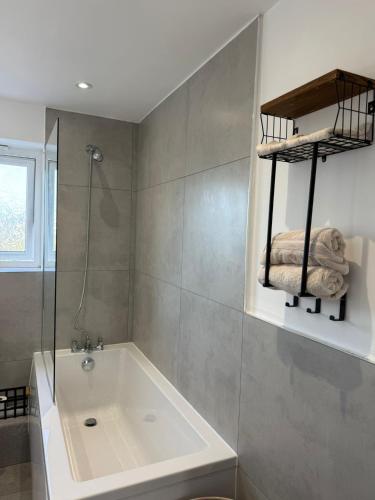 a bathroom with a bath tub and a shower at Modern City Flat, Walk to Hatfield House, Trains and University in Hatfield