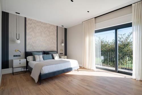 ein Schlafzimmer mit einem Bett und einem großen Fenster in der Unterkunft Relax in Santiago de Compostela in Vedra