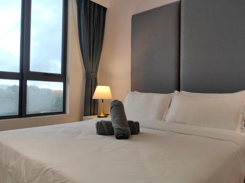 a bedroom with a large white bed with a lamp at Vetro11 Beside QEH1 by JUNE Homestay in Kota Kinabalu