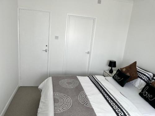 a bedroom with three wardrobes and a bed with a bedspread at Love and Peace, Petts Wood in Orpington