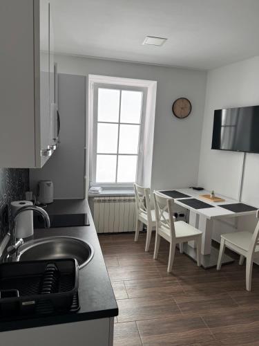 a kitchen with a sink and a table with chairs at SKOL apartments in Celje