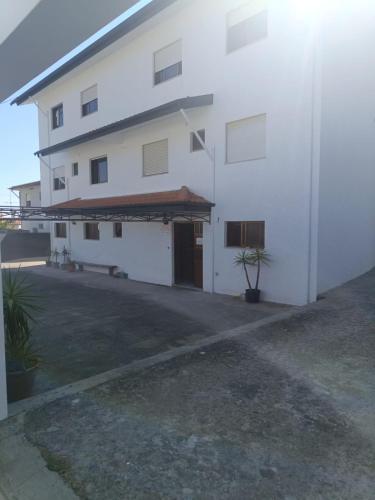 a white building with a garage and a driveway at SOBREIRO - Sobreiro Alojamento - Grijó in Grijó