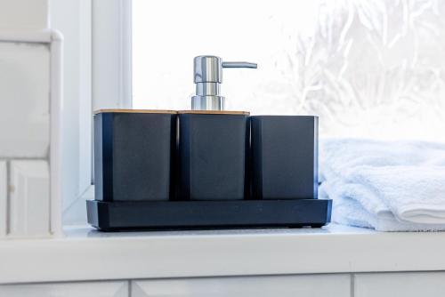 サンダーランドにあるThe Sunderland Spot Family & Work Readyのバスルームカウンターに座る黒石鹸ディスペンサー