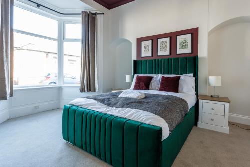 サンダーランドにあるThe Sunderland Spot Family & Work Readyの窓付きのベッドルームの緑色のベッド1台