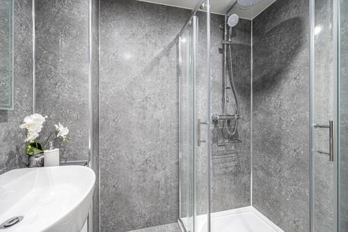 a bathroom with a shower and a sink and a toilet at Super Prime Luxury Waterfront View Dbay By Tba in Saint Davids