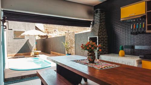 a kitchen with a table with a vase of flowers at Casa Belmond in Capitólio