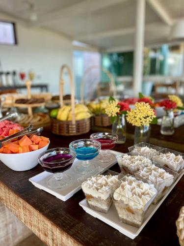 a counter with bowls of food and bowls of fruit at Pousada Bella vista in Búzios