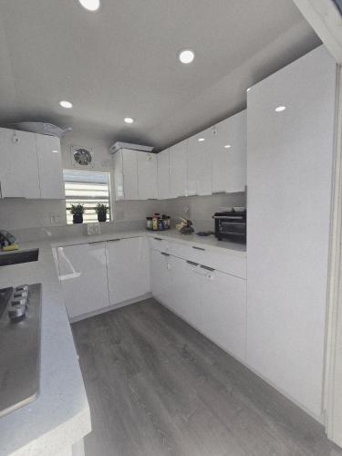 a white kitchen with white cabinets and a window at Gallego Deluxe Rental in Key Largo