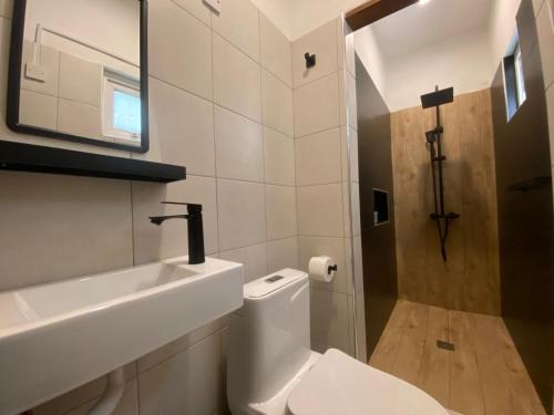 a bathroom with a white toilet and a sink at Le Dauphin Villa 3 Bedroom 5min Walk to Beach - LB2 in Flic-en-Flac