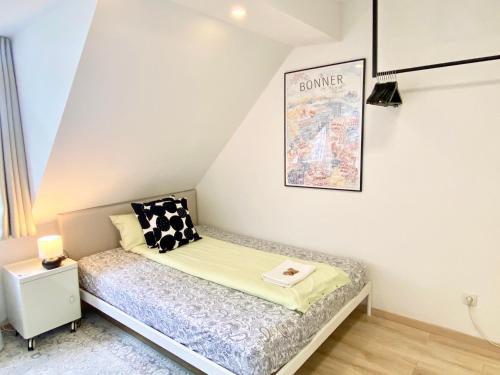 a small bed in a room with a poster on the wall at Zuhause auf Zeit-Gemütliche Gästezimmer in Bonn