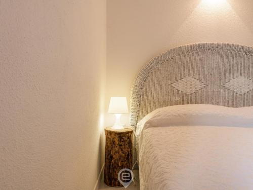 a bedroom with a bed and a lamp on a table at Porto Luna 25 - Hala in Simius
