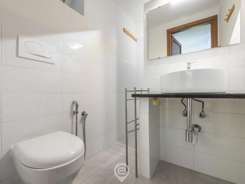 a white bathroom with a toilet and a sink at Porto Luna 25 - Hala in Simius