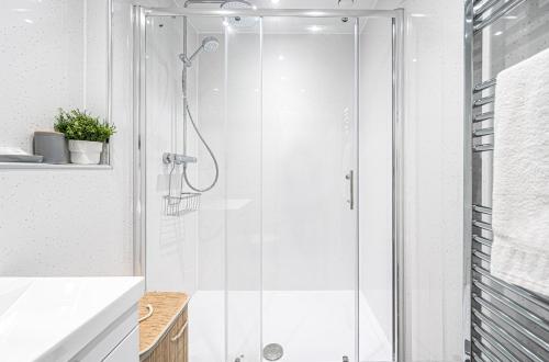 a shower with a glass door in a bathroom at Super Prime Abbey Free Parking By Tba in Dunfermline