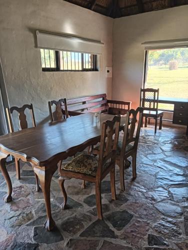 a dining room with a wooden table and chairs at Tersus Riverbend Lodge in Hartbeespoort