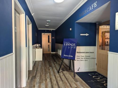 a hallway with blue walls and a sign that reads the lodge at The Lodge by Cefn Tilla in Usk