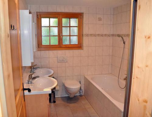 a bathroom with a sink and a tub and a toilet at Cresta in Fiesch