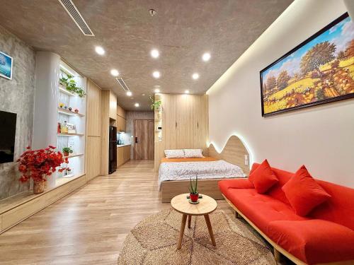 a living room with a red couch and a bed at An An Homestay- Ecopark- Văn Giang- Hưng Yên in HÆ°ng YÃªn